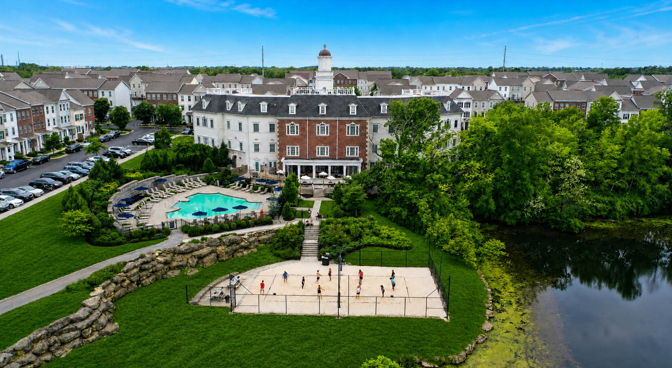 aerial view of ond, sand volleyball pit, pool and clubhouse